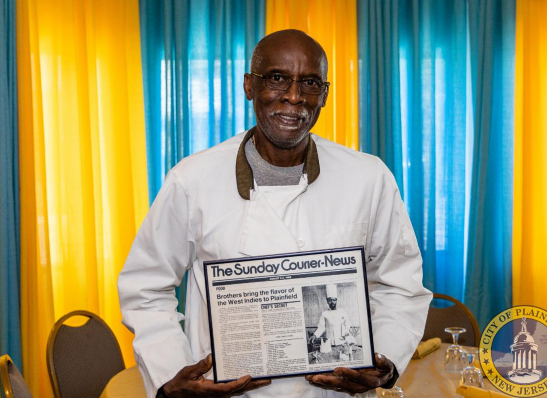 Meet the Owner - Windfield Catwell Standing Inside His Restaurant Holding a Plaque